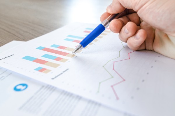 A hand with pen working on a chart