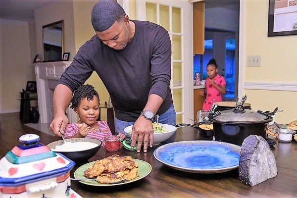 Nick Wallace, Hope member, feeding his toddler in his kitchen