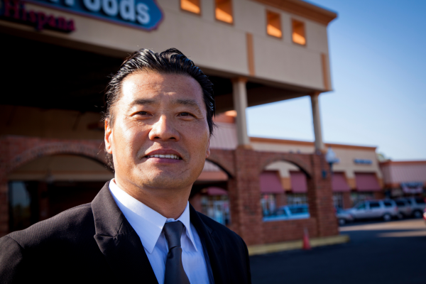 Small business owner and Self-Help credit union member poses outside of his business