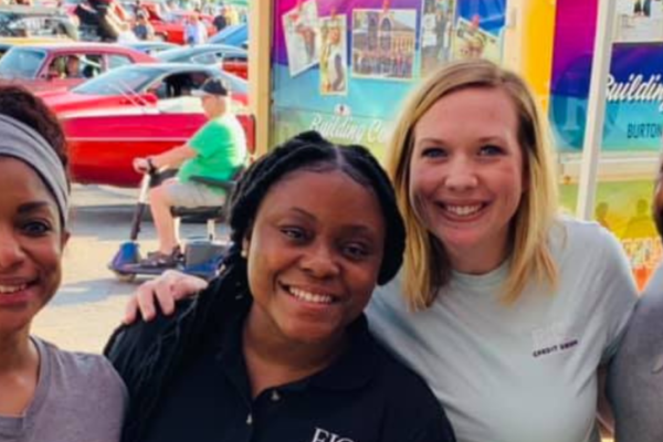 Elga staff and CU members smiling together at a community event