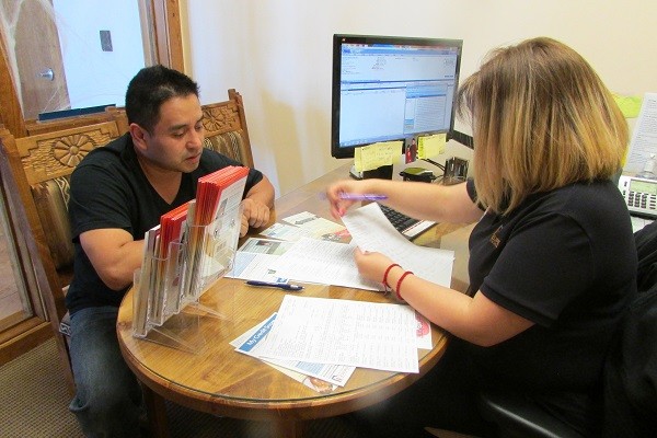 A Guadalupe CU staffer helps a member with paperwork