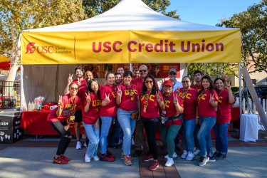 USC Credit Union staff at a community event posing in front of their tent